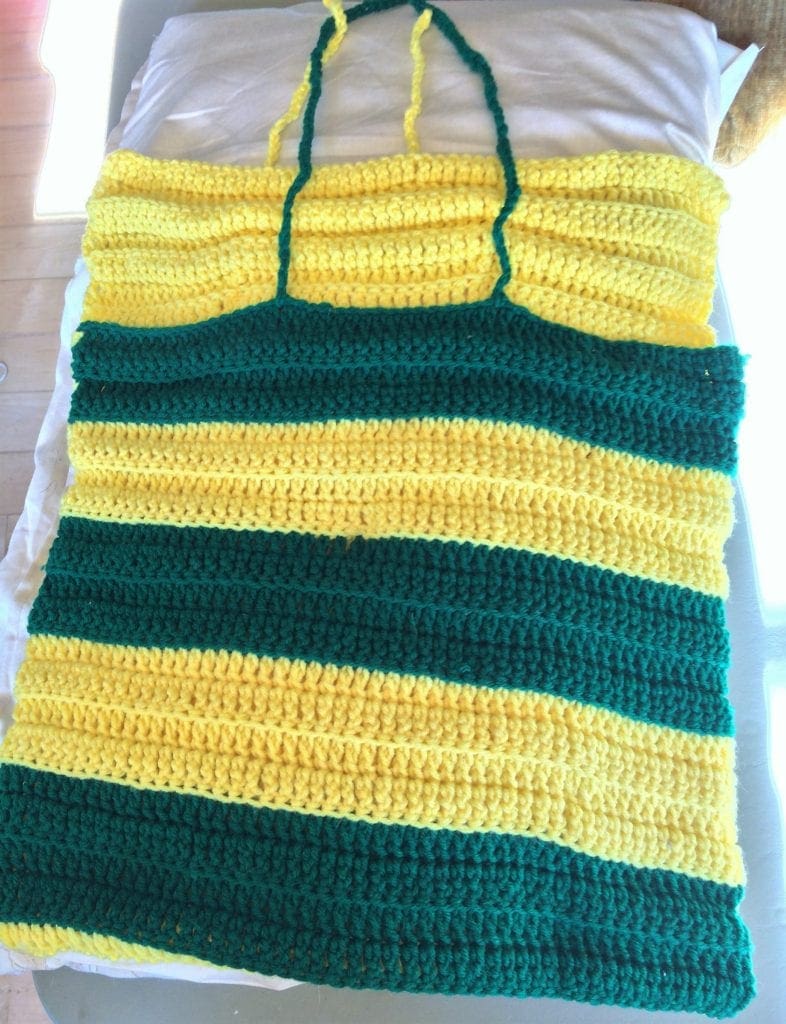 Green and gold crochet pillow covering laying flat