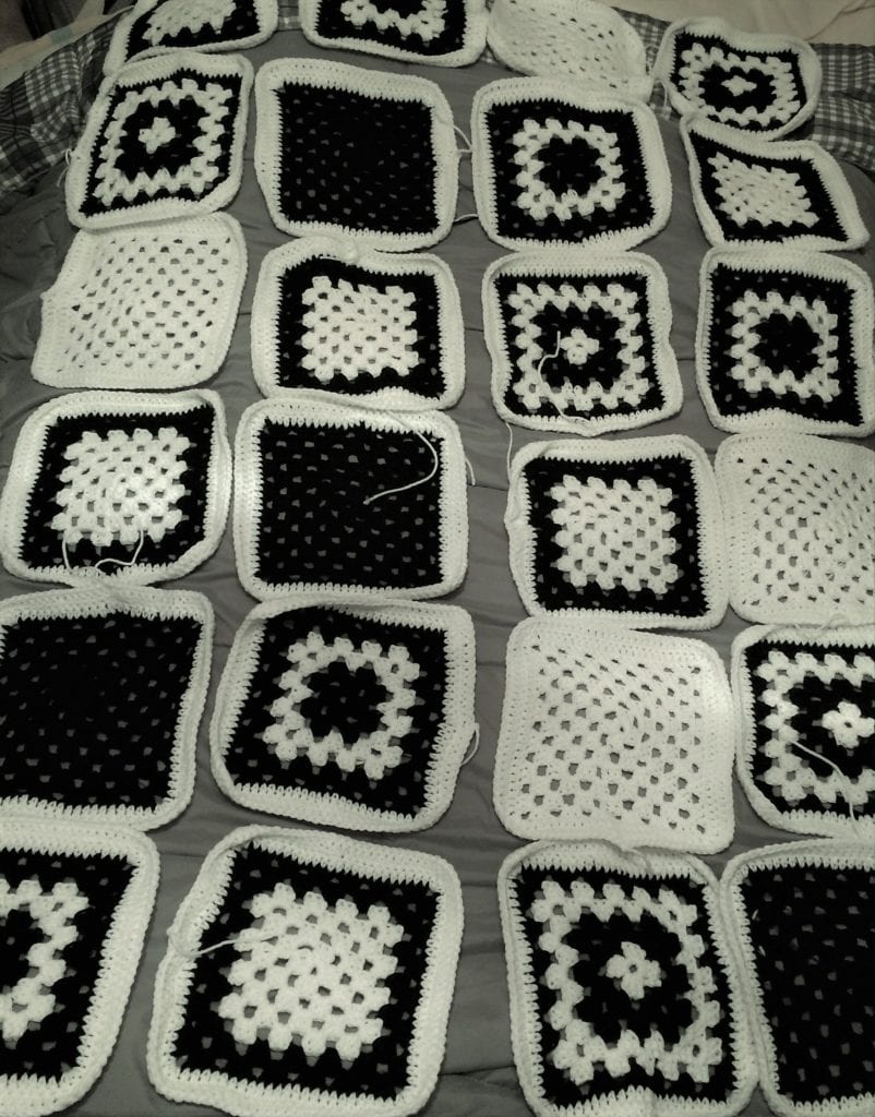 granny squares laying on bed for layout out the blanket pattern