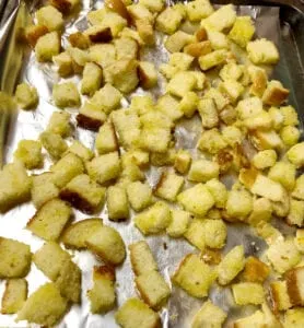 Arranging Homemade Croutons on Foil Lined Cookie Sheet