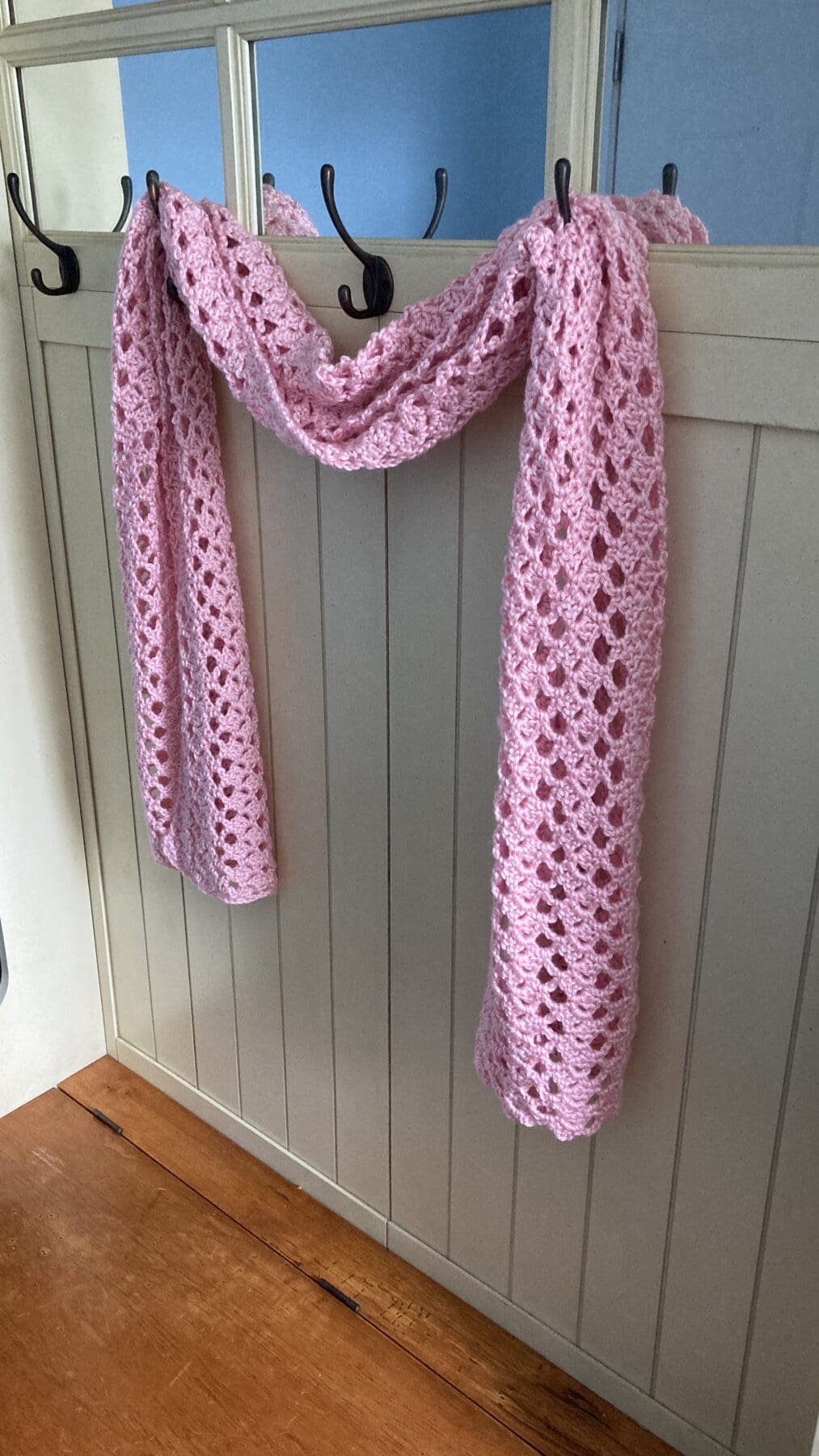 Gorgeous crochet shawl draped over hooks