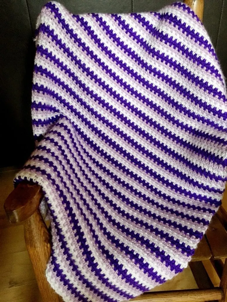 How to crochet a moss stitch baby blanket draped over a chair