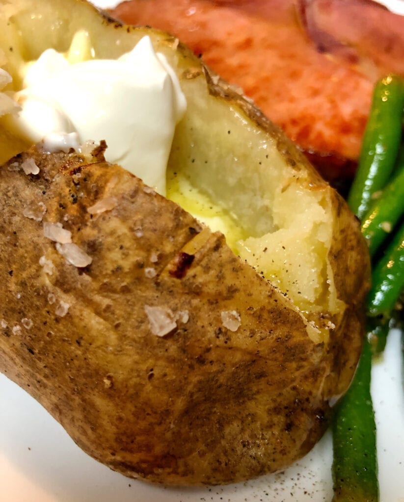 Perfectly Cooked Baked Potato with Sour Cream and Melted Butter
