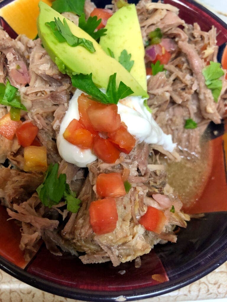 Pork Salsa Verde Served with Avocado Sour Cream Cilantro and Tomatoes