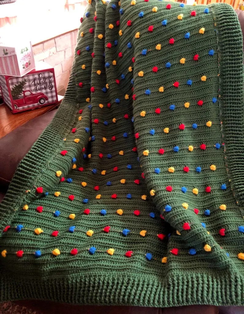 Festive Light Crochet Blanket on the Back of a Leather Sofa