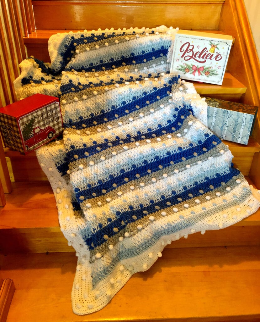 Shades of Blue Crochet Holiday Blanket Displayed with Christmas Decorations