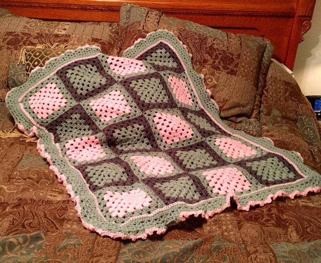 Blushing Ruffle Baby Blanket displayed on bed