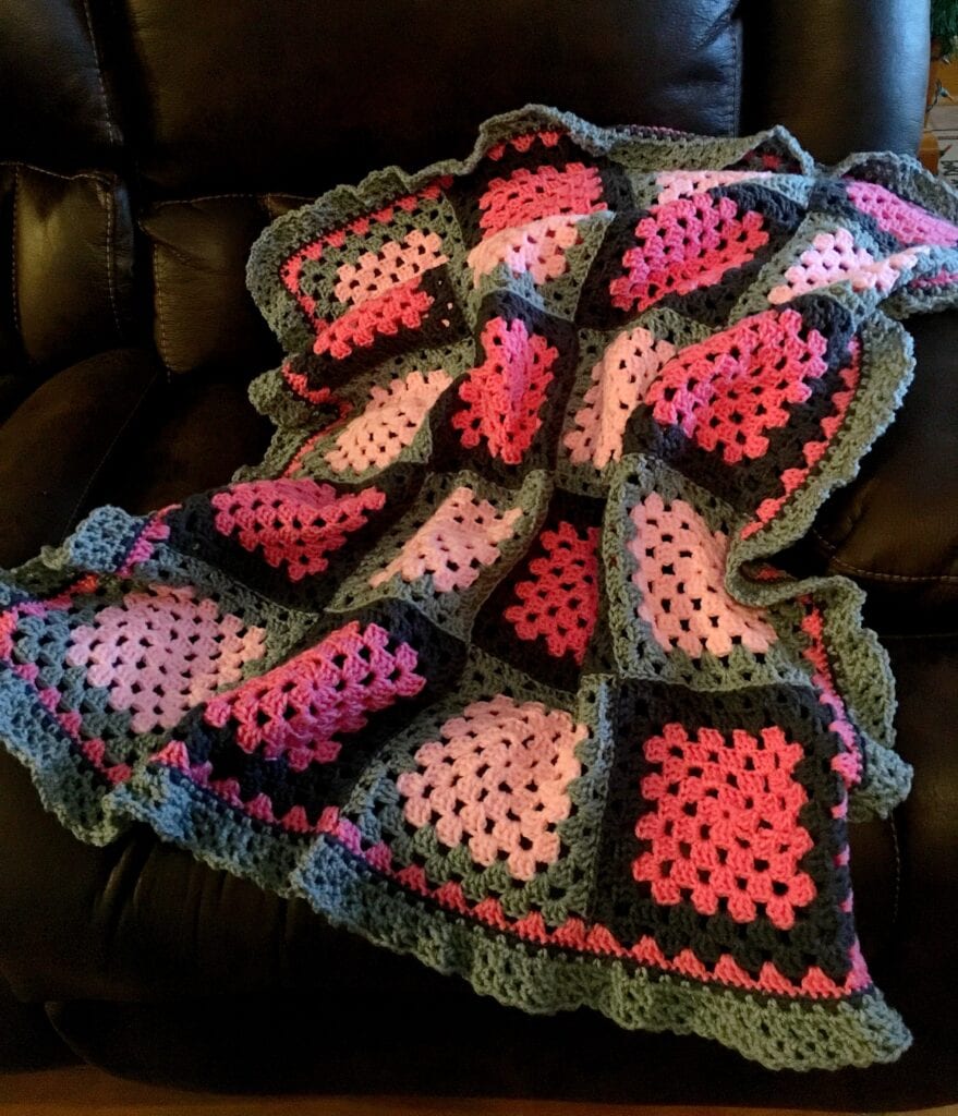 Pink and Grey Baby Blanket Displayed on Sofa