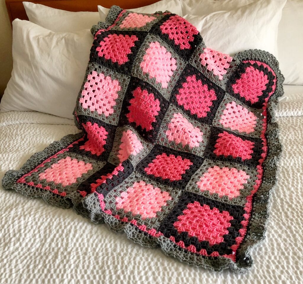 Pink and Grey Granny Square Blanket Shown on Bed