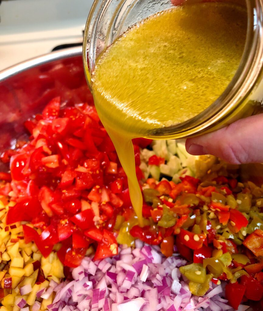 Pouring Salad Dressing Over the Peach Salsa Ingredients
