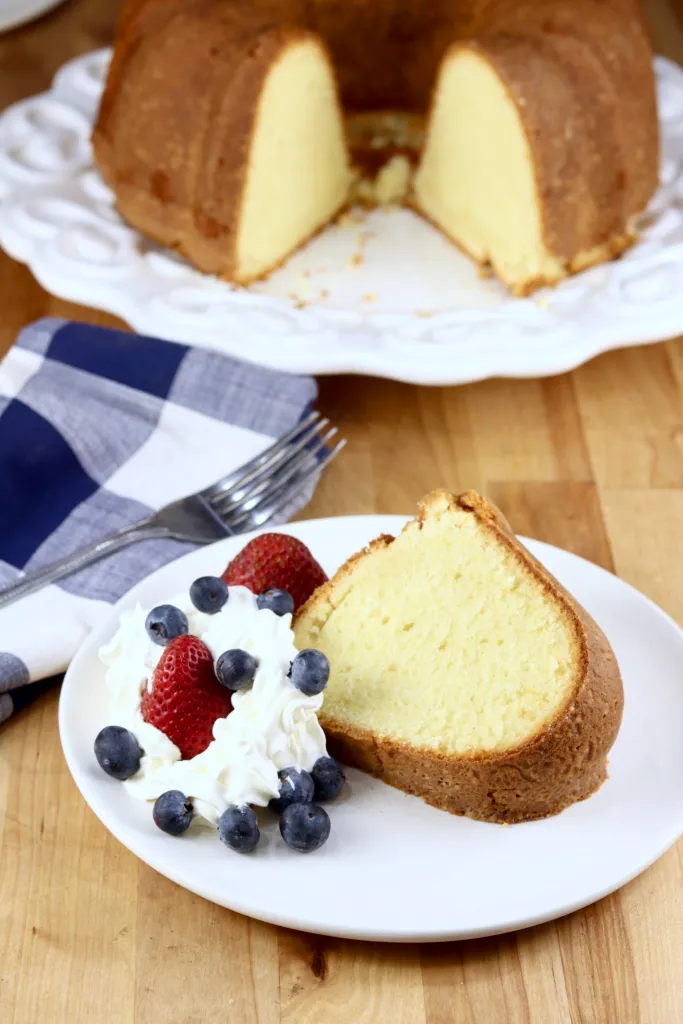 Million-Dollar-Pound-Cake-Recipe sliced with whipping cream and berries